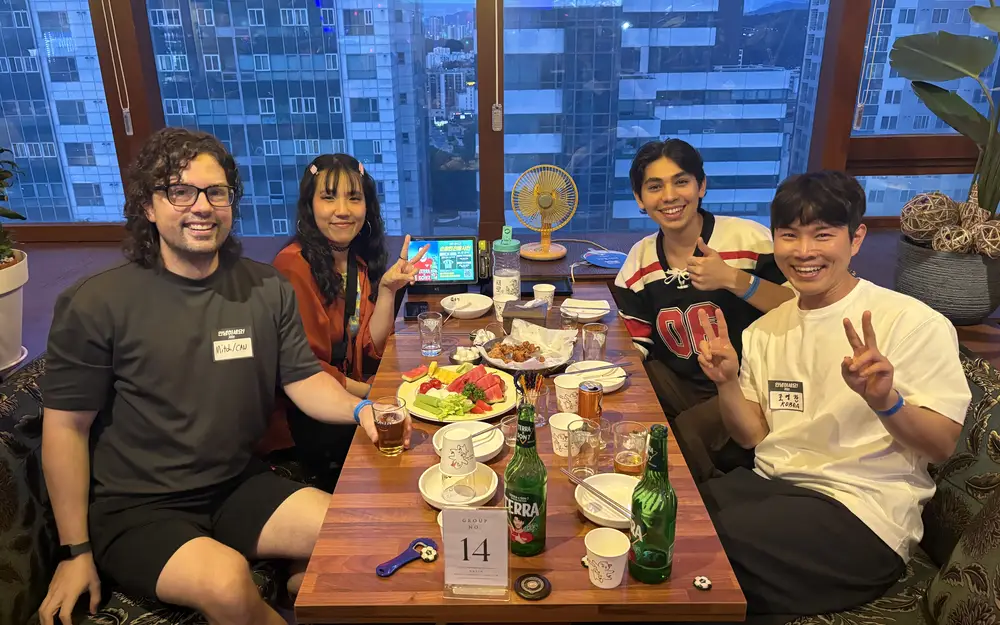 Four guests smiling at their table during a nurio party