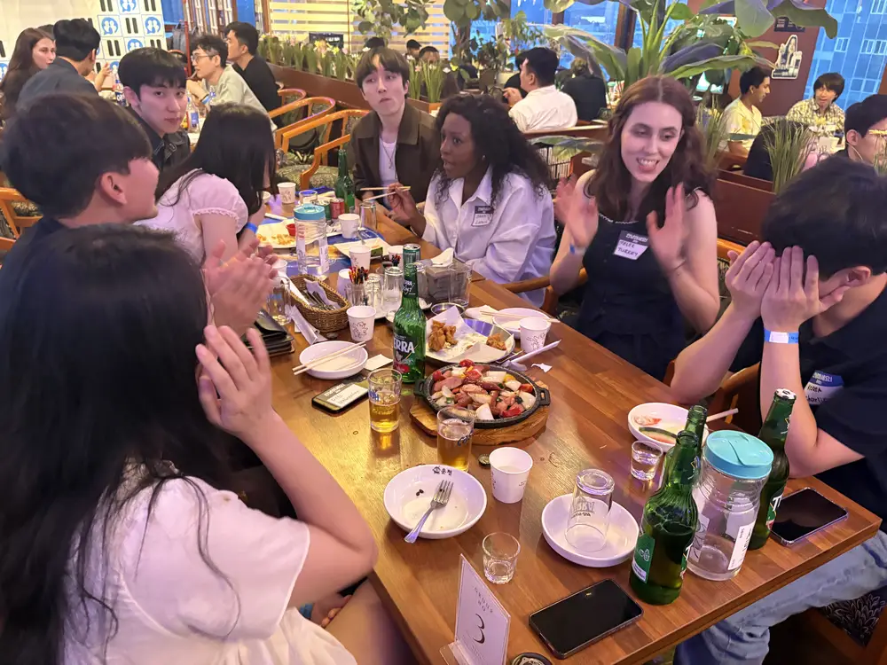 Guests laughing and talking around a table at a nurio international party